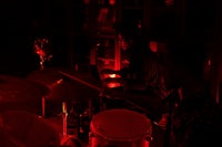 two people playing drums in a dark room