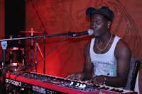 a man playing a keyboard in front of a microphone