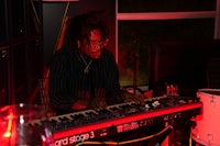 a man with dreadlocks playing a keyboard