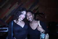 two women standing next to each other at a party
